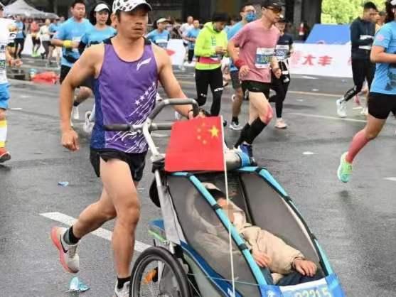 父亲推着脑瘫儿子跑完55场马拉松： “借”我的双腿带他拥抱世界